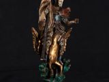 a bronze statue of an angel on a horse with a flag