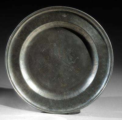 a silver plate with a design on it on a table