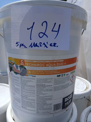 un seau blanc sur lequel est collé un autocollant, posé sur une pile de seaux