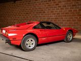 a red sports car parked in front of a brick wall