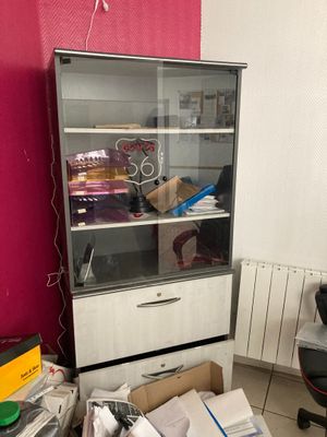 une armoire avec une porte vitrée au milieu d'une pièce