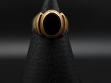 a close up of a gold ring with a black stone in the middle