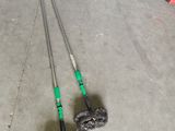 two brooms and a mop on the floor in a garage