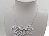 necklace made of silver wire with leaves on a mannequin