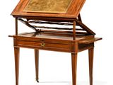 an antique writing table with a wooden top and drawers