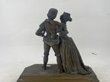 bronze statue of a man and a woman kissing on a stone base
