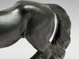 statue of a horse on a marble base on a gray background