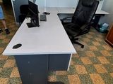 un bureau avec un ordinateur et une chaise dans une pièce
