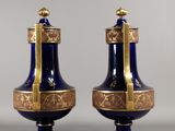 pair of blue and gold vases sitting on top of a table