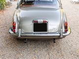 a silver car that is parked in the gravel