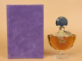 an image of a bottle of perfume next to a purple box