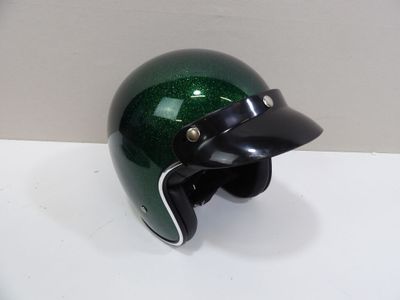 a green helmet with a black visor sitting on a table