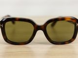 sunglasses on a wooden table with a white wall in the background