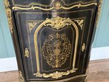 un meuble ancien peint en noir et or, doté d'un plateau en marbre