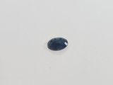 a blue sapphire stone on a white surface