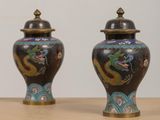 two vases sitting on a table with a dragon painted on them