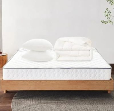 un lit avec des oreillers, sur lesquels sont posés d'autres oreillers, dans une chambre
