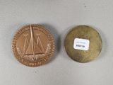 an image of a gold coin with a sailboat on it next to a small coin