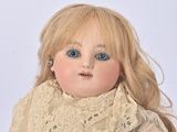 an old doll with blonde hair and blue eyes wearing a white dress