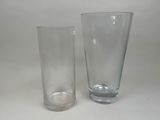 two glass vases sitting next to each other on a table