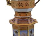 a teapot with a painting on it sitting on a stand