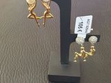 a pair of earrings sitting on a stand with a price tag
