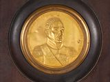 a picture of a gold medal with a picture of a man on it