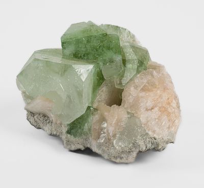 a small piece of rock with green crystals on top of it