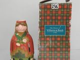 une petite figurine représentant une femme vêtue d'un manteau rouge