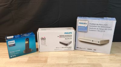 trois boîtes de produits Philips posées sur une table près d'un mur noir