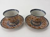 deux tasses et soucoupes sont posées sur une surface blanche