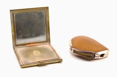 un miroir de poche et un étui de poche posés sur une surface blanche