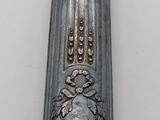 a silver spoon with a gold top on a white table