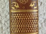an old book sitting on top of a table next to a vase