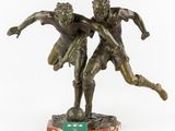 an image of a bronze statue of two men playing soccer