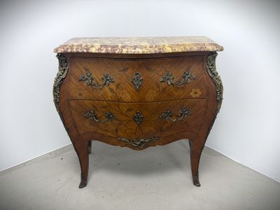 a small chest of drawers with a marble top