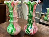 two vases sitting on a table with a mirror in the background