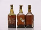 trois bouteilles de bière posées les unes à côté des autres sur une surface blanche