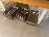 several pans and pans are sitting on the floor in a kitchen