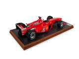 the red ferrari racing car is on display on a wooden base