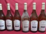 six bottles of wine are lined up in a row on a pink background