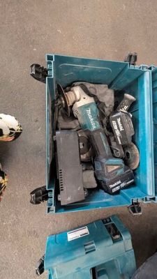 une boîte bleue posée par terre, contenant des outils