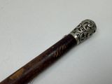 a wooden stick with a metal handle sitting on a table