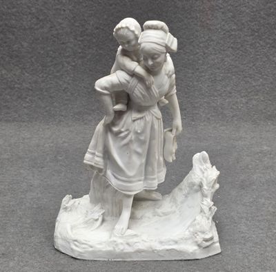 Statuette en biscuit représentant une femme et son enfant.