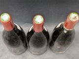 three bottles of wine are lined up on a table