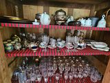 many glasses and plates on the shelves in the cabinet