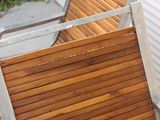 a wooden bench that is leaning against a wall