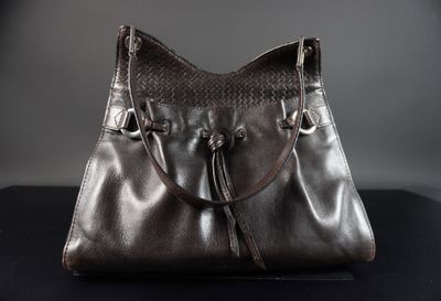 sac à main en cuir marron avec des anses tressées sur un fond noir