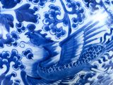 a blue and white vase with a bird on it