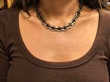 a woman that is wearing a brown shirt and a necklace